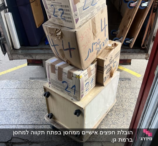 ארגזי קרטון ושידת עץ מועמסים ברכב הובלה